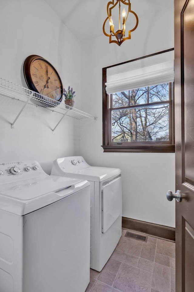 washroom featuring washer and dryer and a notable chandelier