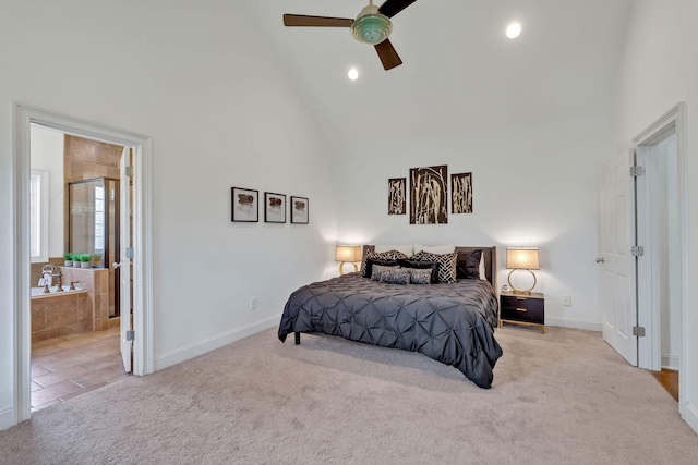 bedroom featuring ceiling fan, light colored carpet, high vaulted ceiling, and connected bathroom