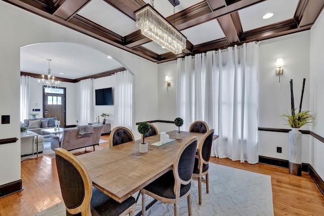 dining room featuring an inviting chandelier, light wood-type flooring, ornamental molding, and coffered ceiling