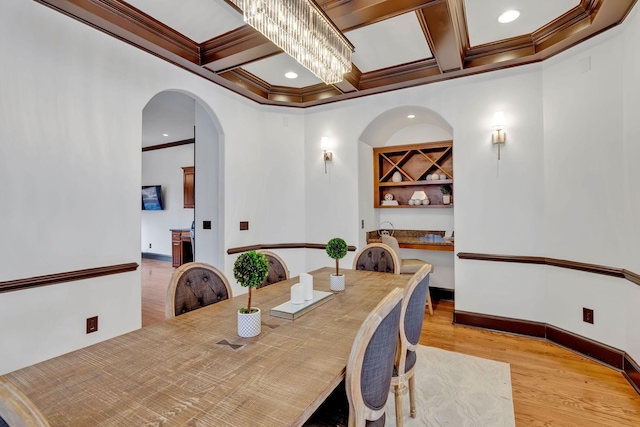 dining room with a chandelier, beam ceiling, crown molding, and coffered ceiling