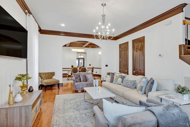 living room featuring crown molding, light hardwood / wood-style flooring, and a notable chandelier