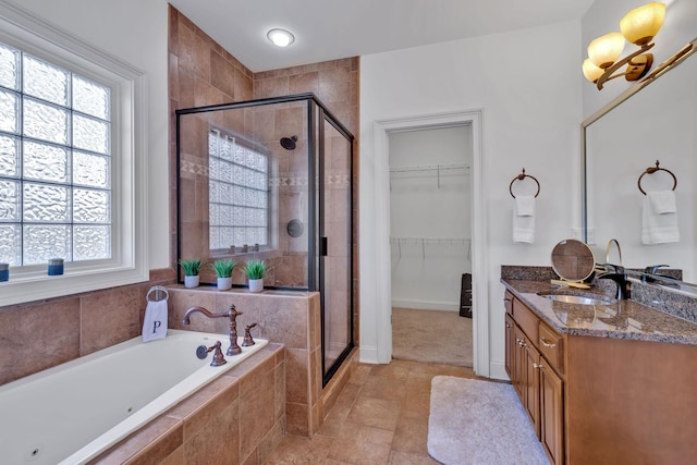 bathroom with tile patterned floors, vanity, plus walk in shower, and a chandelier