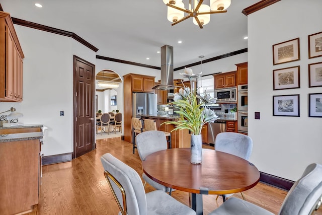 dining space with a chandelier, light hardwood / wood-style flooring, and crown molding