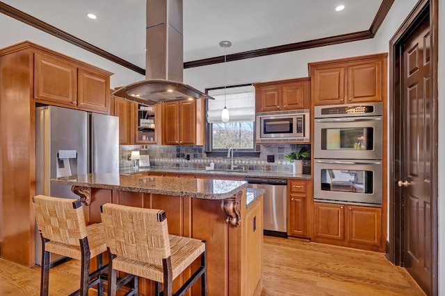 kitchen with dark stone counters, a kitchen breakfast bar, sink, appliances with stainless steel finishes, and island exhaust hood