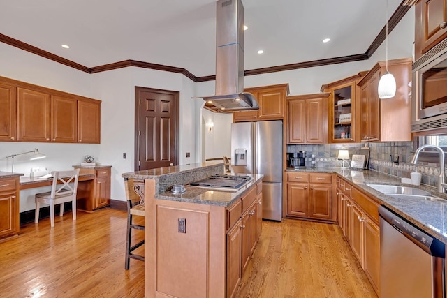 kitchen with a breakfast bar, a kitchen island with sink, sink, island exhaust hood, and stainless steel appliances