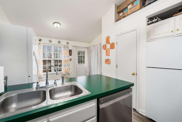 kitchen with dishwasher, white refrigerator, sink, vaulted ceiling, and white cabinetry