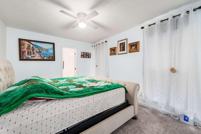 bedroom with ceiling fan, carpet, and a textured ceiling