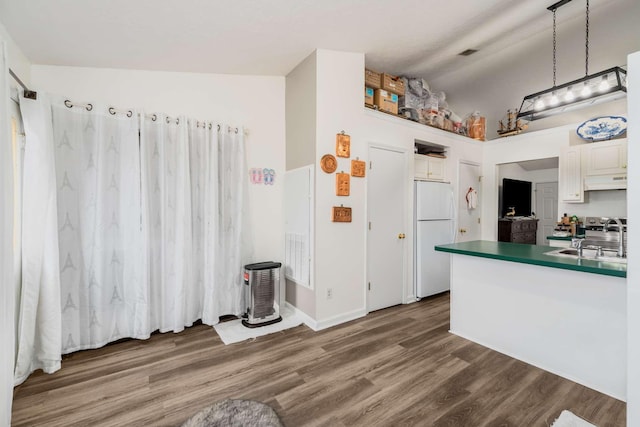 kitchen featuring pendant lighting, white cabinets, white refrigerator, sink, and vaulted ceiling