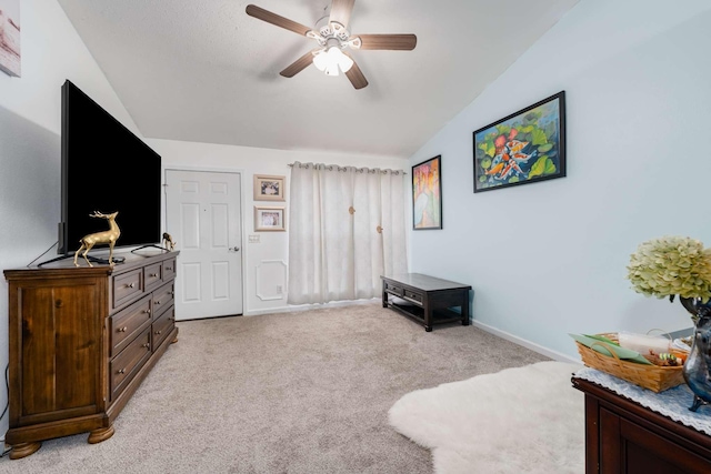 living area featuring ceiling fan, light colored carpet, and lofted ceiling