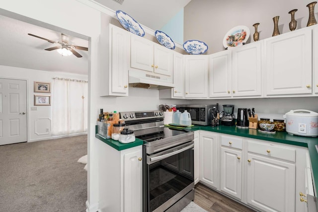 kitchen featuring light carpet, white cabinets, stainless steel appliances, and ceiling fan