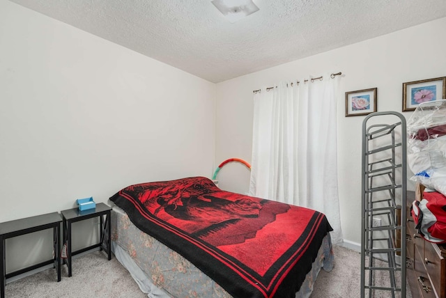 bedroom featuring light carpet and a textured ceiling