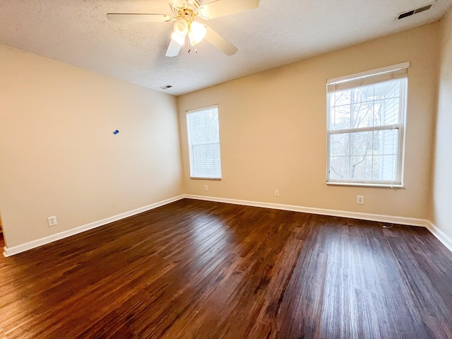 empty room with dark hardwood / wood-style floors, ceiling fan, and a textured ceiling