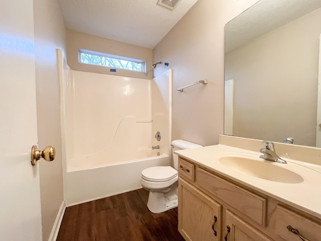 full bathroom featuring vanity, bathing tub / shower combination, toilet, a textured ceiling, and wood-type flooring