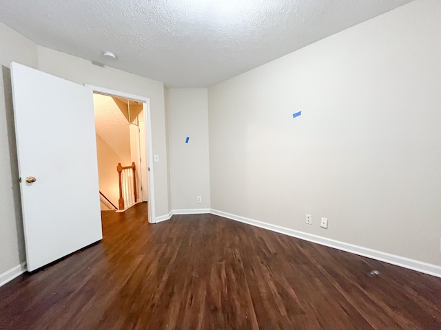 unfurnished room with dark hardwood / wood-style floors and a textured ceiling