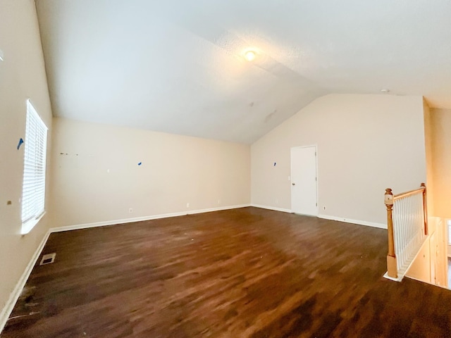 additional living space with dark hardwood / wood-style flooring and vaulted ceiling