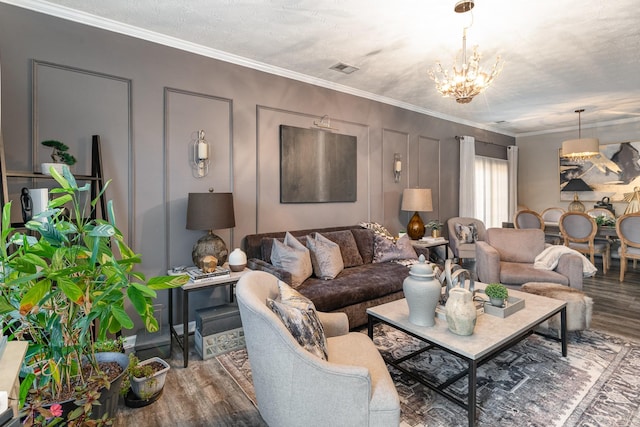 living room featuring a textured ceiling, a notable chandelier, crown molding, and wood-type flooring