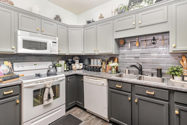 kitchen with white appliances, tasteful backsplash, gray cabinetry, and sink