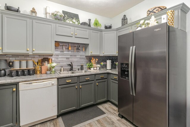 kitchen with sink, dishwasher, gray cabinets, and stainless steel refrigerator with ice dispenser