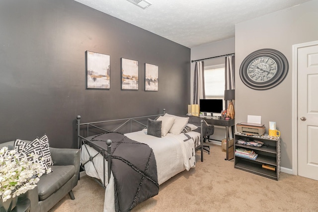 bedroom with a textured ceiling and light colored carpet