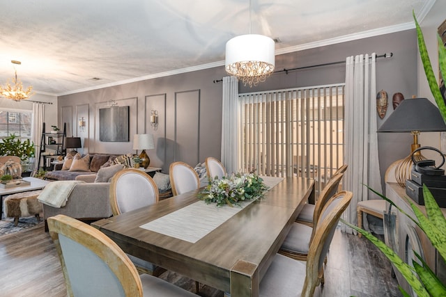 dining space featuring light hardwood / wood-style floors, ornamental molding, and a chandelier