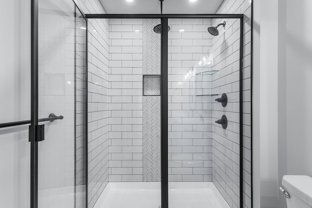 bathroom featuring walk in shower and toilet