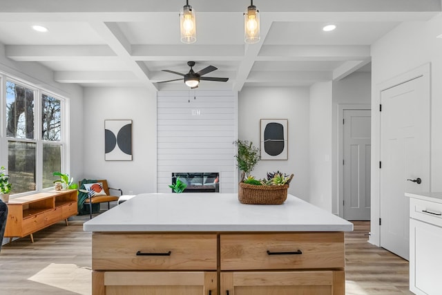 kitchen featuring beam ceiling, ceiling fan, light brown cabinets, hanging light fixtures, and light hardwood / wood-style floors