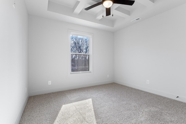 spare room featuring carpet flooring, ceiling fan, beam ceiling, and coffered ceiling