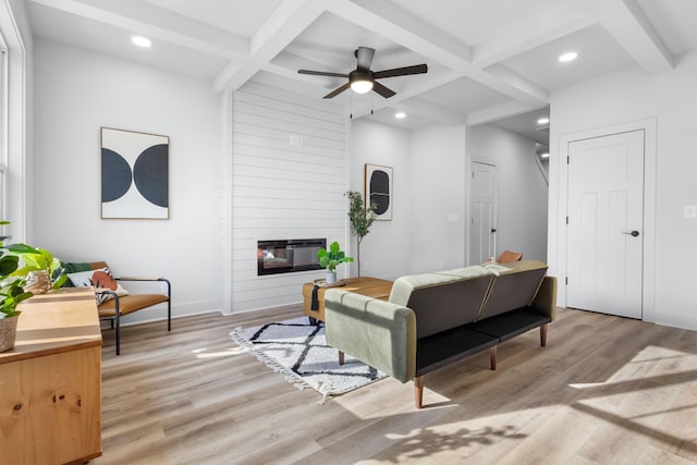 living room with beamed ceiling, a fireplace, and coffered ceiling