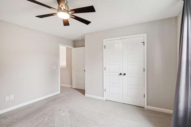 unfurnished bedroom featuring ceiling fan, light carpet, and a closet