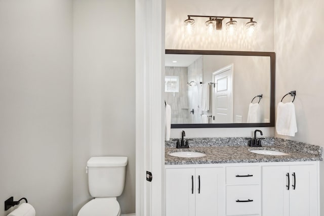 bathroom with vanity, toilet, and tiled shower