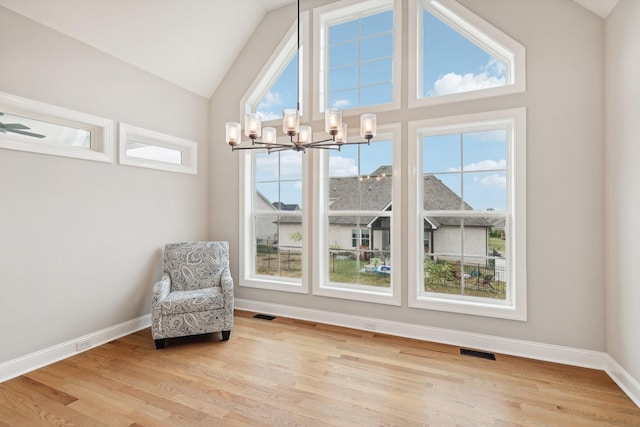 unfurnished room with lofted ceiling, light wood-type flooring, and a chandelier