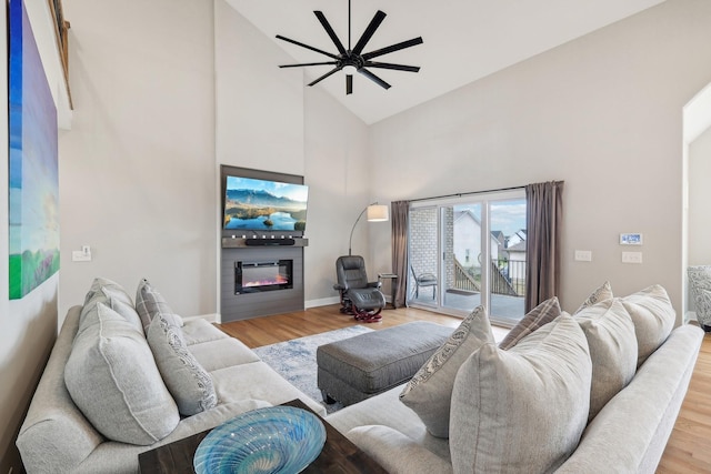 living room with hardwood / wood-style floors, high vaulted ceiling, and ceiling fan