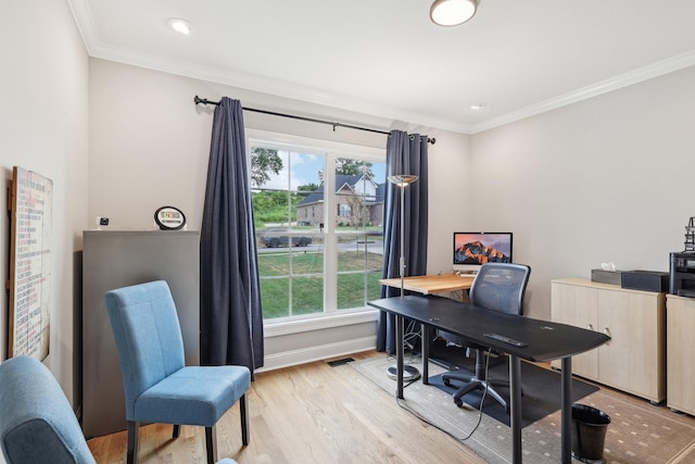 office area with light wood-type flooring, plenty of natural light, and ornamental molding