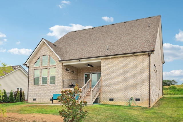 rear view of property featuring ceiling fan and a lawn