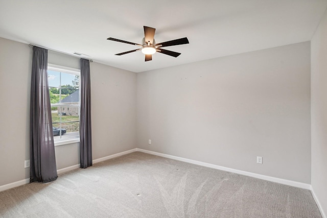 carpeted spare room featuring ceiling fan