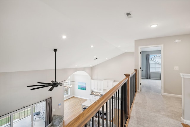 corridor featuring light colored carpet and lofted ceiling