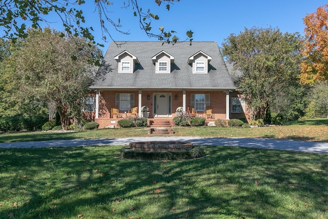 cape cod home featuring covered porch and a front lawn