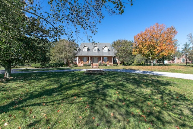 cape cod-style house featuring covered porch and a front lawn