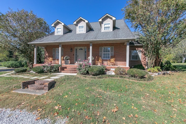 new england style home featuring a porch and a front yard