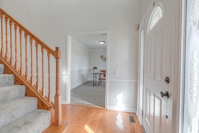 foyer entrance featuring light wood-type flooring and crown molding