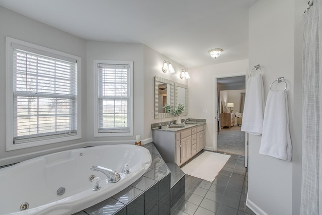 bathroom with tile patterned floors, tiled tub, and vanity