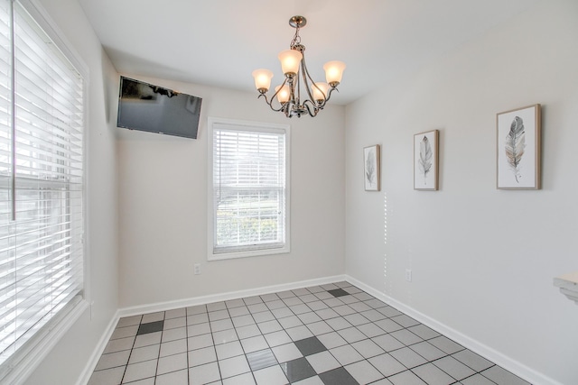 unfurnished room featuring an inviting chandelier and tile patterned floors