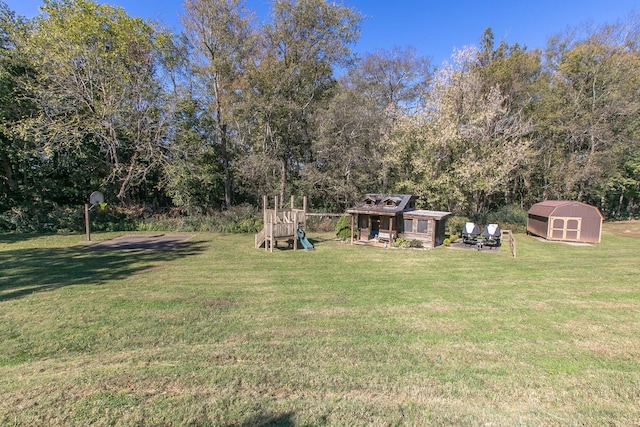 view of yard with a storage shed and a playground