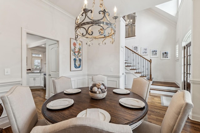 dining space featuring dark hardwood / wood-style flooring, an inviting chandelier, and ornamental molding