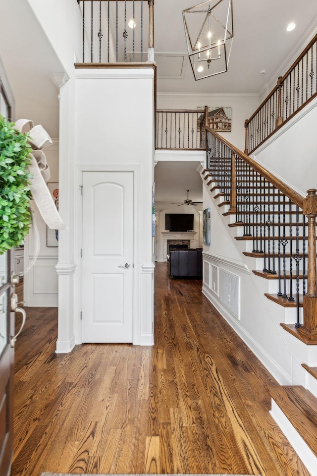 foyer with hardwood / wood-style flooring, ceiling fan, and crown molding