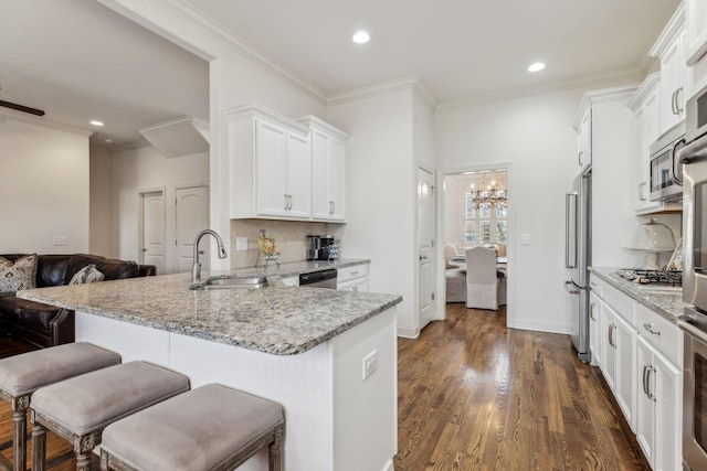 kitchen featuring sink, dark hardwood / wood-style floors, light stone counters, white cabinetry, and stainless steel appliances