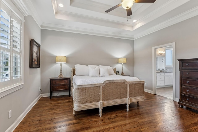 bedroom with a raised ceiling, ensuite bath, ceiling fan, ornamental molding, and dark hardwood / wood-style flooring