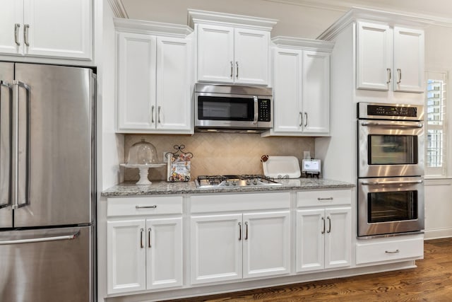 kitchen featuring backsplash, dark wood-type flooring, white cabinets, light stone countertops, and stainless steel appliances