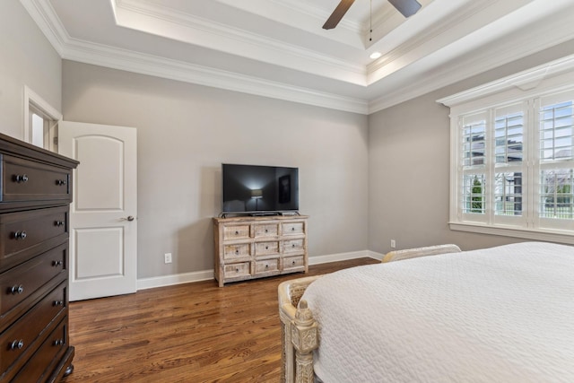 bedroom featuring a tray ceiling, ceiling fan, crown molding, and dark hardwood / wood-style floors