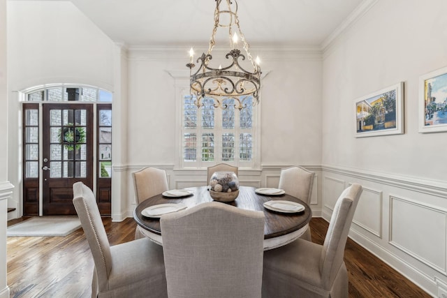 dining area with hardwood / wood-style flooring, a notable chandelier, a healthy amount of sunlight, and ornamental molding